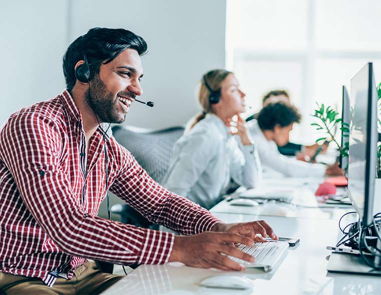 Sales representatives wearing headset working at their desks