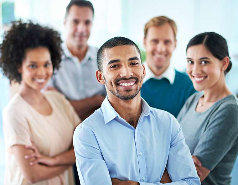 Five workers smiling in the workplace