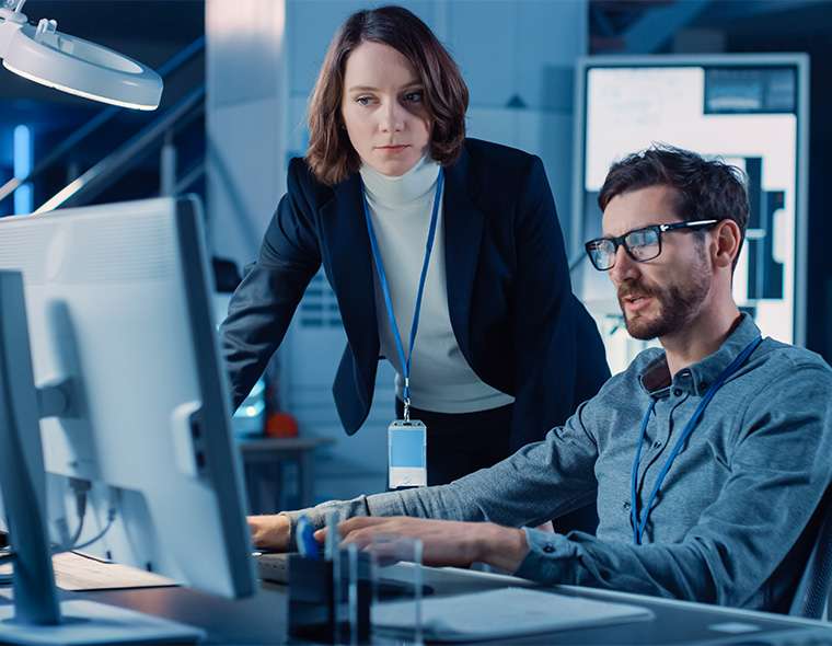 Two workers solving a technical challenges around a computer